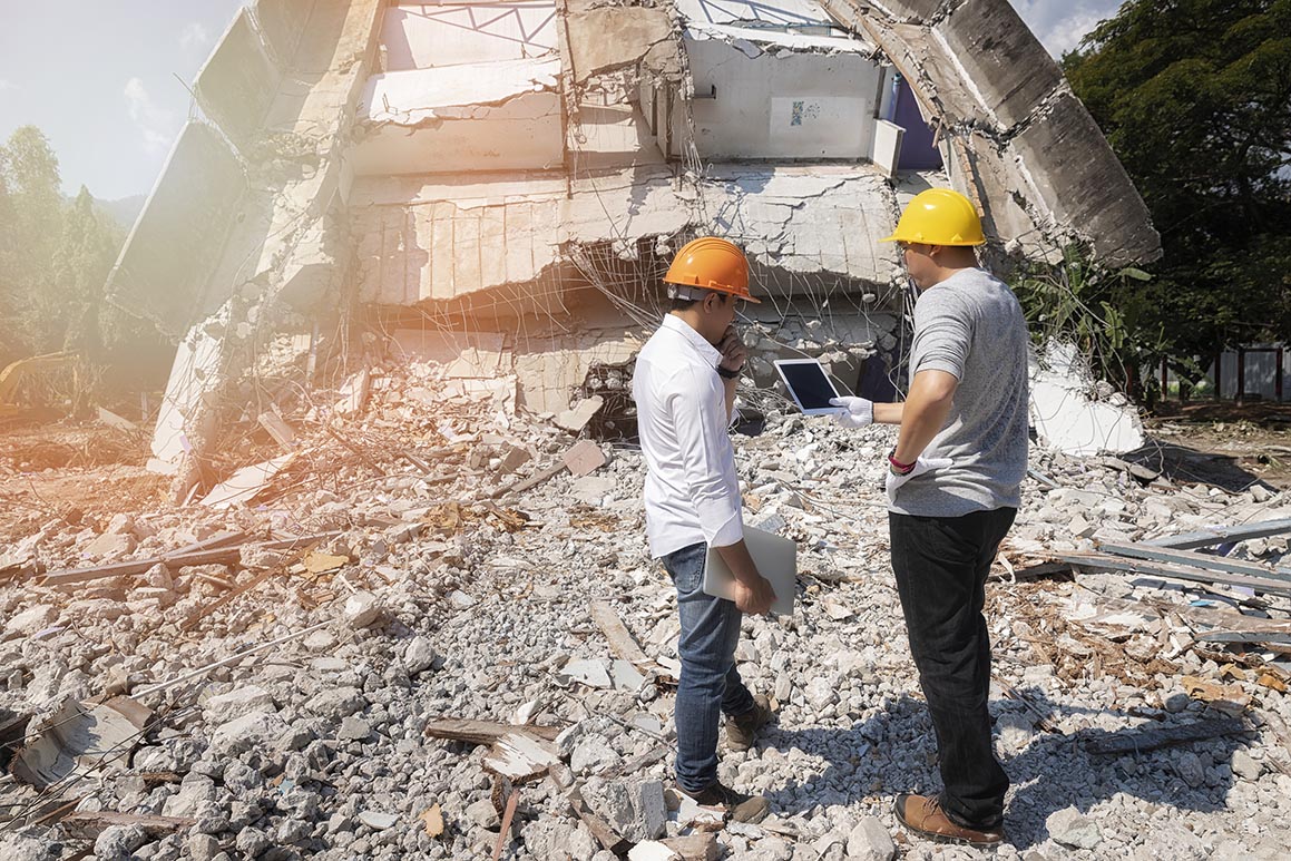 Demolition control supervisor and foreman discussing on demolish building.